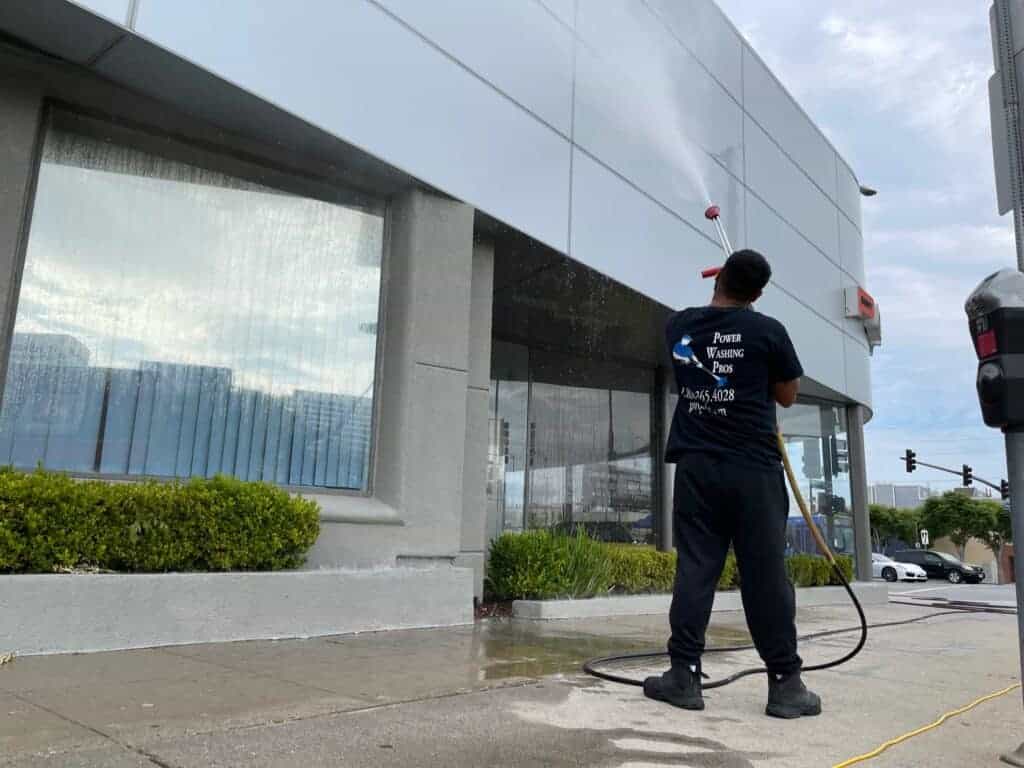 Close up of a car dealership building getting power washed