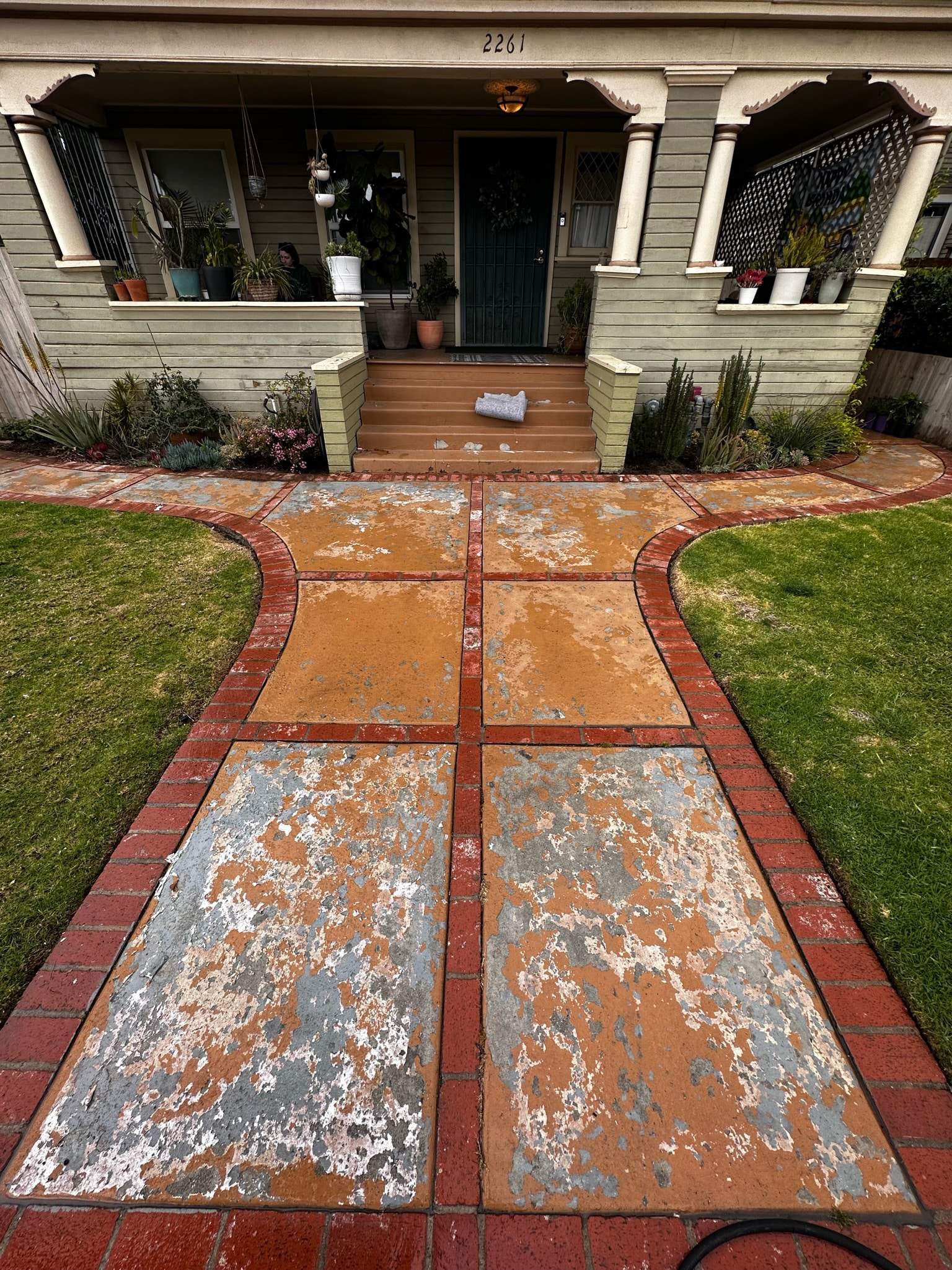 a concrete brick walkway to a home before cleaning and sealing