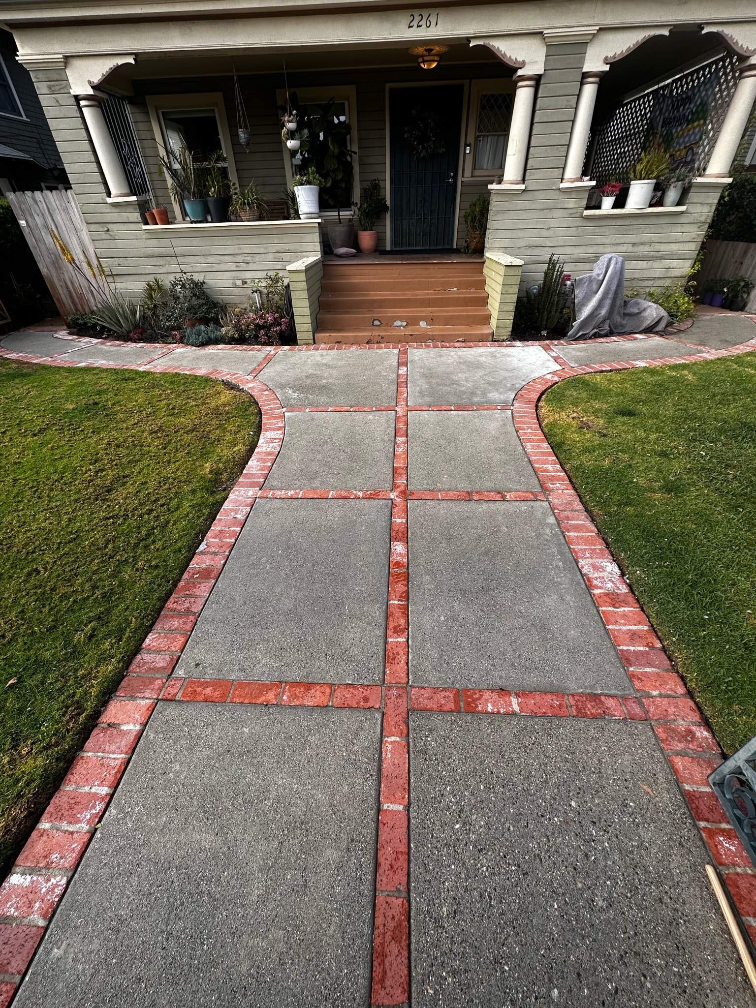 a concrete and bring walkway to a home after it cleaning and sealing